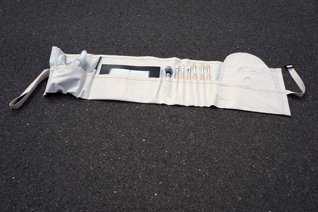 photo of an artist's tool roll laid out on the ground